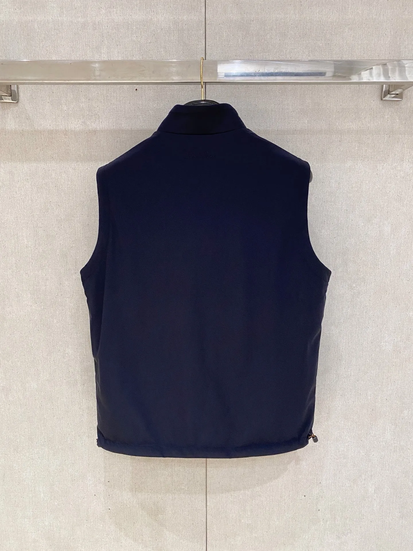 Loro Piana Reversible Stand-up Collar Vest Fabric: The front is made of high-elastic anti-wrinkle functional windproof fabric, which is smooth and waterproof, waterproof and stain-resistant, not easy to wrinkle, light and crisp; the back is made of worsted wool knitted fabric, which is soft to the touch and skin-friendly, breathable and constant temperature, one pair of fabrics, taking into account outdoor practicality and home leisure comfort, it is an old-money classic Italian commuter fabric. Design highlights: Double-wear dual-style design, the functional side is smart and business-like, and the knitted side is soft and elegant, allowing you to switch between two atmospheres when wearing one set; The brand logo is embroidered with the same color on the left chest, which is low-key and subtle, unobtrusive and highlights the texture; Brown trim strips are spliced ​​on the side of the pocket, with metal snaps, and the light luxury details are full; The collar is closed with contrasting brown and yellow striped ribs, and the hem has drawstring adjustments on both sides to tighten the fit. Version and structure: Improved high stand-up collar tailoring, fits the neck without getting stuck, and modifies the shoulder and neck lines; Slightly loose straight cut, accommodates all body shapes, can be worn with shirts, polo, and thin knitted fabrics without restraint; Symmetrical welt pockets with metal snap buckles for stable storage of items and preventing them from slipping. Style positioning: Light business commuting, Premium casual, outdoor travel wear, minimalist, low-key and noble, Versatile is a must-have item for mature men. Color: Black, Navy Blue (the reverse side is Gray knitted surface) Sizes: M-4XL
